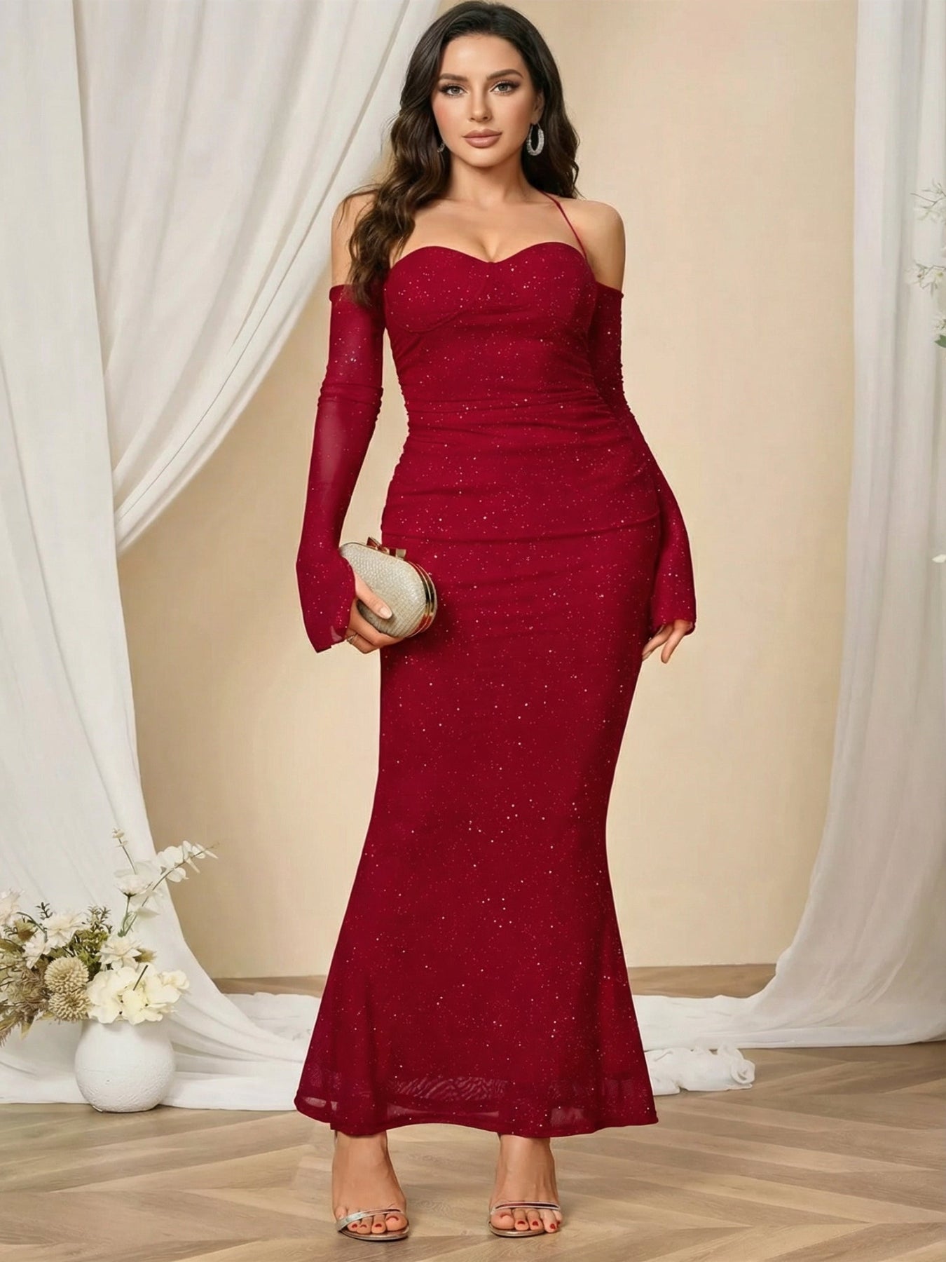Woman wearing a burgundy evening gown with long sleeves in a room with white curtains.