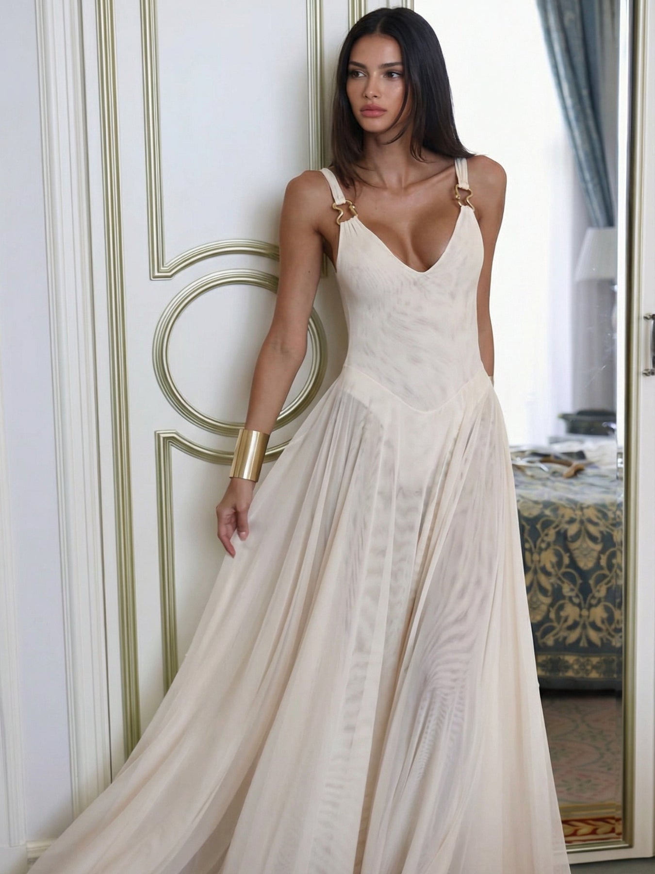 Woman wearing a white lace dress in an elegant room.